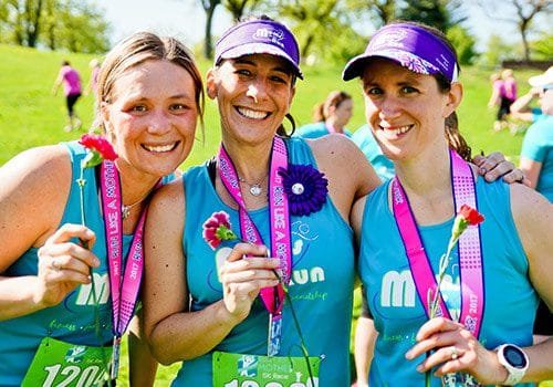 3 MOTR members holding flowers
