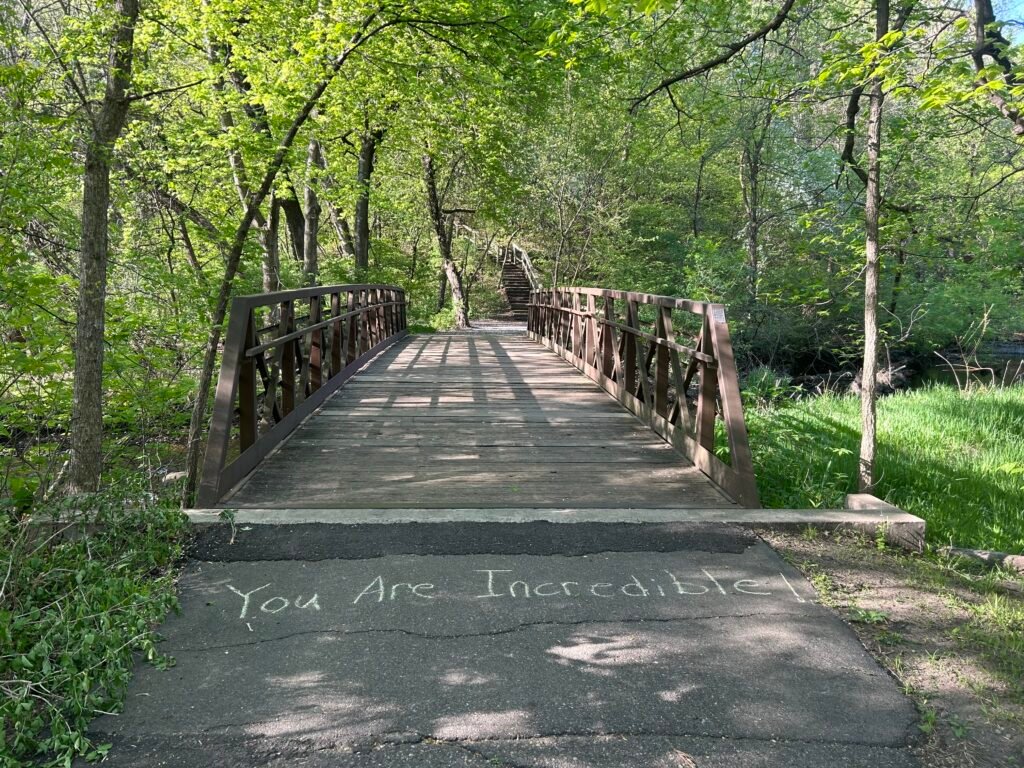 Running path with sidewalk chalk that says you are incredible